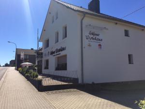 ein weißes Gebäude an der Straßenseite in der Unterkunft Höfener Wirtshaus in Monschau