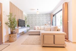 Tehautahi Cozy Lodge 3 في بابيت: غرفة معيشة مع أريكة وتلفزيون