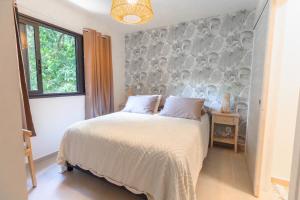 Tehautahi Cozy Lodge 3 في بابيت: غرفة نوم بسرير بجدار رمادي وابيض