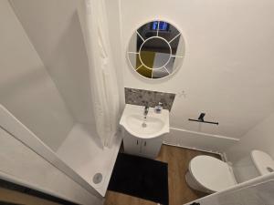 a small bathroom with a sink and a mirror at Stokey Six in London +1 photo