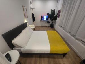 a small bedroom with a bed with a yellow blanket at Stokey Six in London