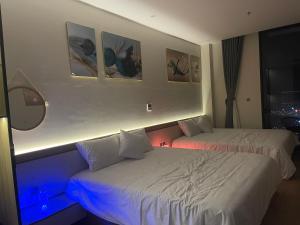 two beds in a hotel room with lights on the wall at HomeStay ICON40 HẠLONG in Ha Long +4 photos