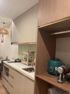 a kitchen with white cabinets and a green appliance at HomeStay ICON40 HẠLONG in Ha Long