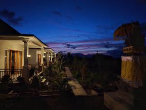 Umaku Bali Homestay في Gobleg: منزل مطل على الجبال ليلا +صورتان