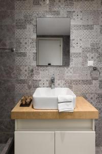 un bagno con lavandino e specchio di Tsimiski View CityCenter Boutique Suite - By Nuvia Domus a Salonicco Altre 8 foto