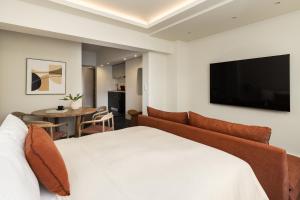 una camera con un grande letto e una TV a schermo piatto di Tsimiski View CityCenter Boutique Suite - By Nuvia Domus a Salonicco
