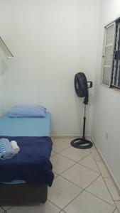 a bedroom with a bed and a fan in a room at KITNET - Completa e Individual - Pousada Itapetininga in Itapetininga