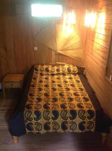 a bed in a room with a quilt on it at Casa Ediana in Trindade