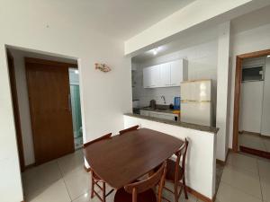 a kitchen with a wooden table and chairs in it at Apartamento com vista da Baía do Pontal in Ilhéus