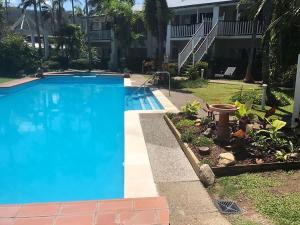 a large blue swimming pool in front of a house at Sunrise Cove in Airlie Beach