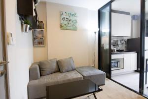 a living room with a couch and a kitchen at The Base 88-67 F5 in Pattaya