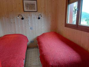 una camera da letto con un letto rosso e una finestra di Chalet in St Maurice near Ballon d'Alsace a Saint-Maurice-sur-Moselle