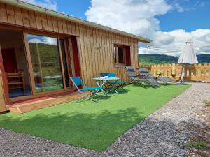 un patio con sedie e un tavolo sull'erba di Chalet in St Maurice near Ballon d'Alsace a Saint-Maurice-sur-Moselle