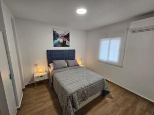 a bedroom with a bed and a window with two lamps at Casa Hernán Cortés in Málaga