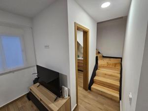 a living room with a television and a staircase at Casa Hernán Cortés in Málaga