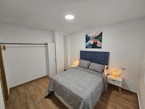 a bedroom with a bed and two lamps on a floor at Casa Hernán Cortés in Málaga +3 photos