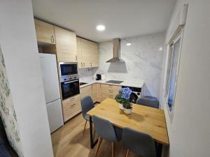 a kitchen with a wooden table and blue chairs at Casa Hernán Cortés in Málaga