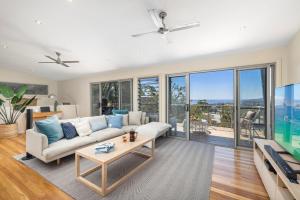 a living room with a couch and a table at Hamptons By The Bay in Nelson Bay