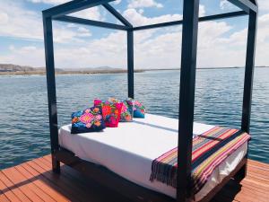 普诺Titicaca Lodge uros的水面上船后部的床