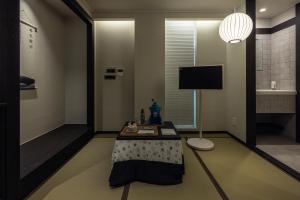 a living room with a table and a tv at Stay Passport Sapporo Ryokan Seoul Hongdae in Seoul