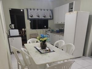 a kitchen with a table with a vase of flowers on it at Terraço do Sol apt 02 in Marcelino Ramos