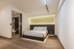a bedroom with a large bed and a bathroom at Green House Hotel in Salento