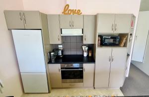 a small kitchen with white cabinets and a stove at Cosy 3BR Home with Breathtaking Views in Queenstown +26 photos