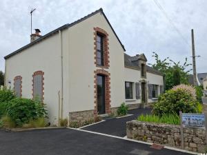 a white building with red brick windows on a street at Ty Yé in Sarzeau