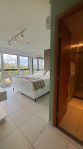 a bedroom with a bed and a large window at Apt beira-mar no Eco Resort Praia dos Carneiros in Praia dos Carneiros +30 photos