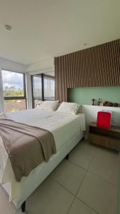a bedroom with a large bed and a window at Apt beira-mar no Eco Resort Praia dos Carneiros in Praia dos Carneiros