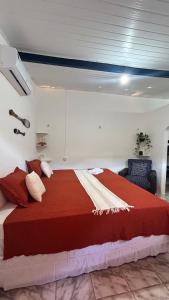 a bedroom with a large bed with a red blanket at Suite Canoa Azul Broadway in Aracati