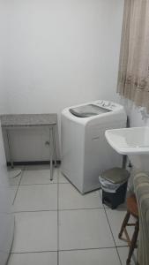 Un baño blanco con inodoro y lavabo. en Apto linda vista, en Osório