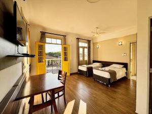 a hotel room with two beds and a table and a desk at Imperial Cidade Smart Suítes in Ouro Preto