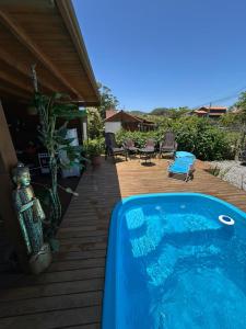 uma piscina sentada num deque de madeira ao lado de uma casa em Cabanas de Marina em Imbituba