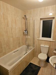 Un baño con bañera, inodoro y lavabo. en Victor's guesthouse, en Waterford