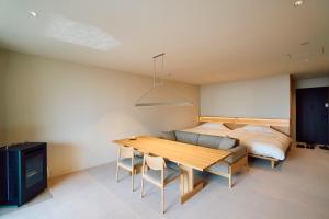 a bedroom with a bed and a wooden table and a couch at SANU 2nd Home Nasu 3rd in Nasu