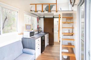 een tiny house met een keuken en een wastafel bij Hidden Camp's Loft House by Tiny Away in Kanighan