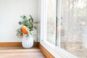 een witte vaas met een bloemstuk in een raam bij Hidden Camp's Loft House by Tiny Away in Kanighan +29 foto's
