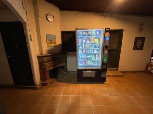 库里科Habitación doble con Jacuzzi的房间里有一台自动售货机，旁边还有一个壁炉。