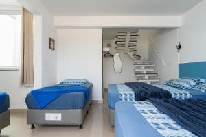 阿拉亚尔-杜卡布Cobertura na Orla da Praia Grande的一间有两张床和楼梯的卧室