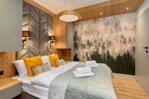 Un dormitorio con una cama grande con toallas. en REST4U APARTAMENTY z SAUNAMI, en Szczyrk