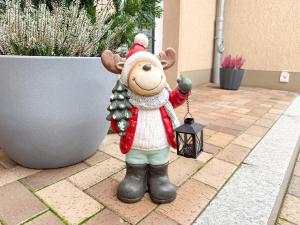 una estatua de un reno sosteniendo una linterna en WILD&COZY Ferienhaus mit luxuriöser Küche & Garage, en Blankenburg