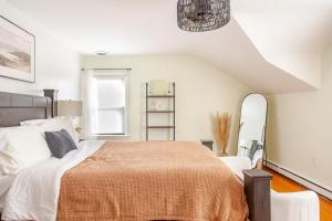 a bedroom with a large bed with an orange blanket at Elegant Spacious Retreat Perfect For Families in Wilmington