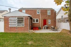 a brick house with a red door and a patio at Elegant Spacious Retreat Perfect For Families in Wilmington