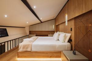 a bedroom with a large white bed with wooden walls at Green House Hotel in Salento +73 photos