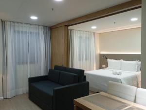 a bedroom with a bed and a couch and a chair at Hotel Internacional Plaza Paulista in Sao Paulo