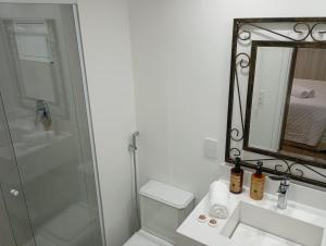 a bathroom with a shower and a sink and a mirror at Hotel Internacional Plaza Paulista in Sao Paulo
