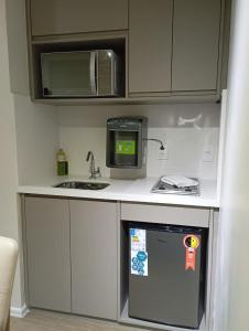 a small kitchen with a sink and a microwave at Hotel Internacional Plaza Paulista in Sao Paulo +10 photos