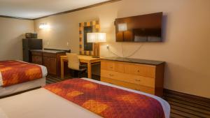 een hotelkamer met een slaapkamer met een bed en een bureau bij Gated 2 Double Bed Studio with Full Kitchen 108 in Baton Rouge