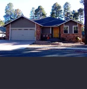 ein Backsteinhaus mit Garage auf einer Straße in der Unterkunft Highland Mesa Getaway in Flagstaff